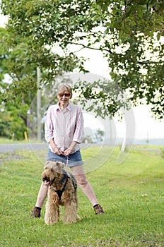 Happy carefree woman walking best friend dog in countryside