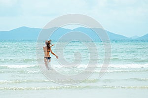 Happy carefree woman wearing bikini having fun on summer vacation