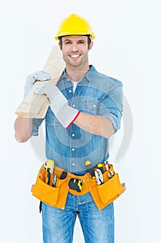 Happy carpenter carrying wooden planks