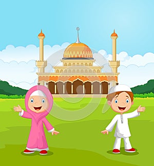 Happy cartoon Muslim kids waving hand in front of mosque photo