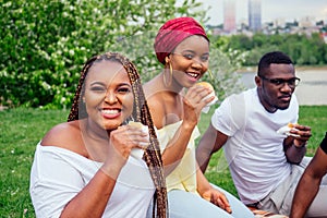 Happy casual america african people having fun and eating burger outdoors lifestyle,students for a break summer evening