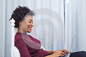 Happy casual beautiful american african woman working on laptop computer