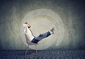 Happy casual business man sitting on chair with feet up relaxing