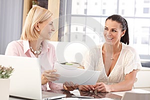 Happy casual businesswomen at office working