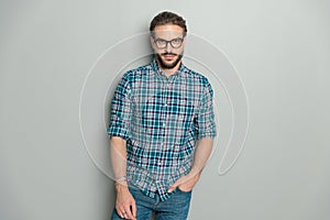 happy casual guy with glasses wearing plaid shirt and holding hand in pocket