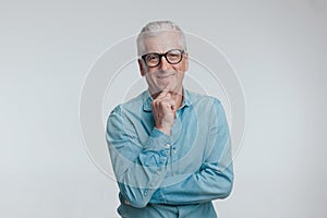 happy casual man in denim shirt touching chin and thinking