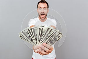 Happy casual man giving money on camera