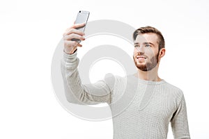 Happy casual man taking selfie over white background