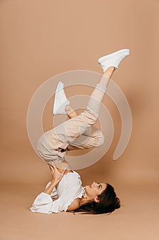 Happy casual woman lying on the floor with raised legs up over pastel background. Lady, cute.