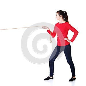 Happy casual woman pulling a rope with ease
