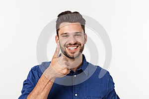 Happy casual young man showing thumb up and smiling isolated on white background.