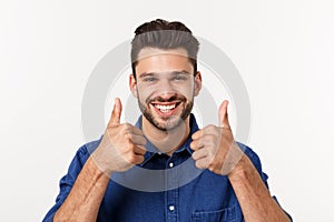 Happy casual young man showing thumb up and smiling isolated on white background.