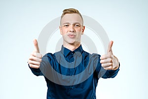 Happy casual young man showing thumbs up gesture