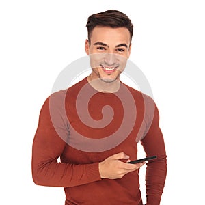 Happy casual young man texting on his phone