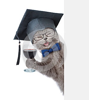 Happy Cat with black graduation cap holding a wineglass behind a white and blank banner. isolated on white background