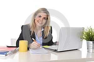 Happy Caucasian blond business woman working on laptop computer at modern office desk