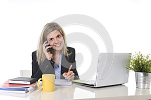 Happy Caucasian blond business woman working talking on mobile phone at office computer desk