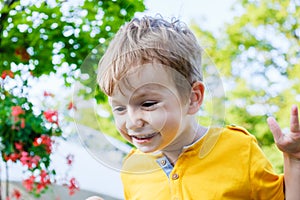 Happy caucasian boy smiling enjoying life. Portrait of young boy in nature, park or outdoors. Concept of happy family