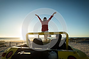 Happy caucasian couple on beach during sunset woman sitting on beach buggy man sitting in