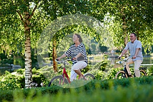 Happy caucasian couple cycling outdoors.