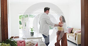 Happy caucasian couple dancing together in living room, slow motion