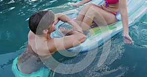 Happy Caucasian couple enjoying the pool during a sunny day