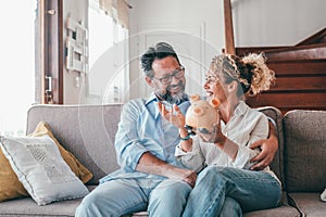 Happy caucasian couple holding piggy bank to save money to make their future dreams come true. Loving man and woman holding piggy