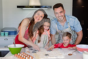 Happy caucasian family baking together, making cookies in kitchen