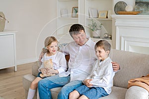 Happy caucasian family at home, cute son and daughter hugging dad, father