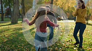 Happy Caucasian family in park parents with little child kid play game outdoors autumn daughter girl run dad running to