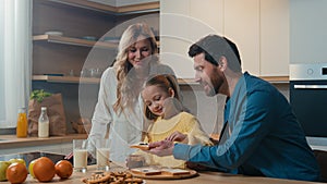 Happy Caucasian family preparing breakfast together talking at home kitchen mother hold glasses with milk little
