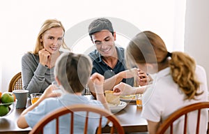 Happy caucasian family with teenage daughter and son smiling and talking while having breakfast in modern kitchen. Family,healthy,