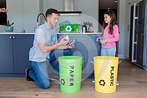 Happy caucasian father and daughter segregating rubbish