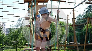 Happy Caucasian girls in an adventure park in protective gear on a summer day. Rope park. nature walks. Physical health