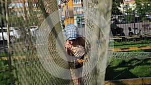 Happy Caucasian girls in an adventure park in protective gear on a summer day. Rope park. nature walks. Physical health