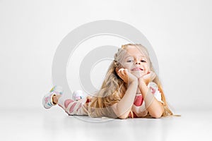 Happy Caucasian little girl posing isolated over white studio background.