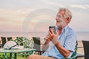 Happy caucasian male using smartphone for chat and selfie