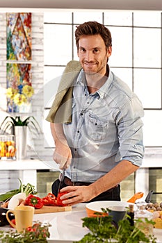 Happy caucasian man cooking in kitchen at home photo