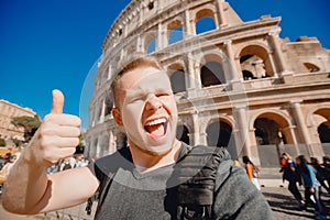 Happy caucasian man tourist with backpack taking selfie photo Colosseum in Rome, Italy. Travel trip concept