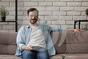 Happy Caucasian man watch TV relaxing in living room