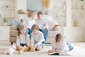 Happy caucasian parents are relaxing on cozy sofa in living room at home. Small