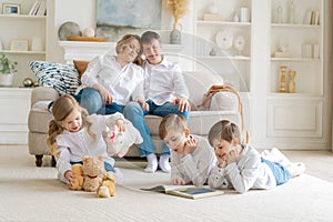 Happy caucasian parents are relaxing on cozy sofa in living room at home. Small