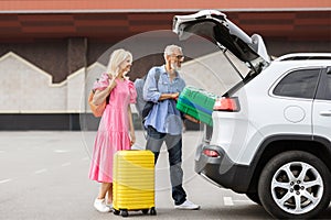 Happy caucasian senior couple going car trip together