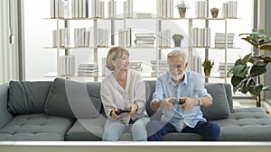 Happy Caucasian senior couple playing games at home