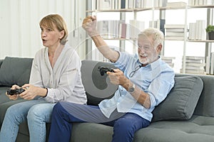 Happy Caucasian senior couple playing games at home