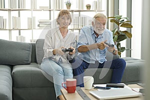 Happy Caucasian senior couple playing games at home