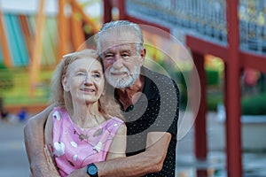 Happy Caucasian Senior couples hugging from behind and have fun and spend time together at theme park