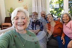 Happy caucasian senior woman doing selfie and smiling in sunny living room, copy space