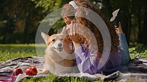 Happy Caucasian woman girl listen music headphones in park city weekend outdoors playing lovely dog welsh corgi breed