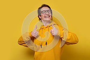 Happy caucasian woman in glasses showing thumb up approving your choice.